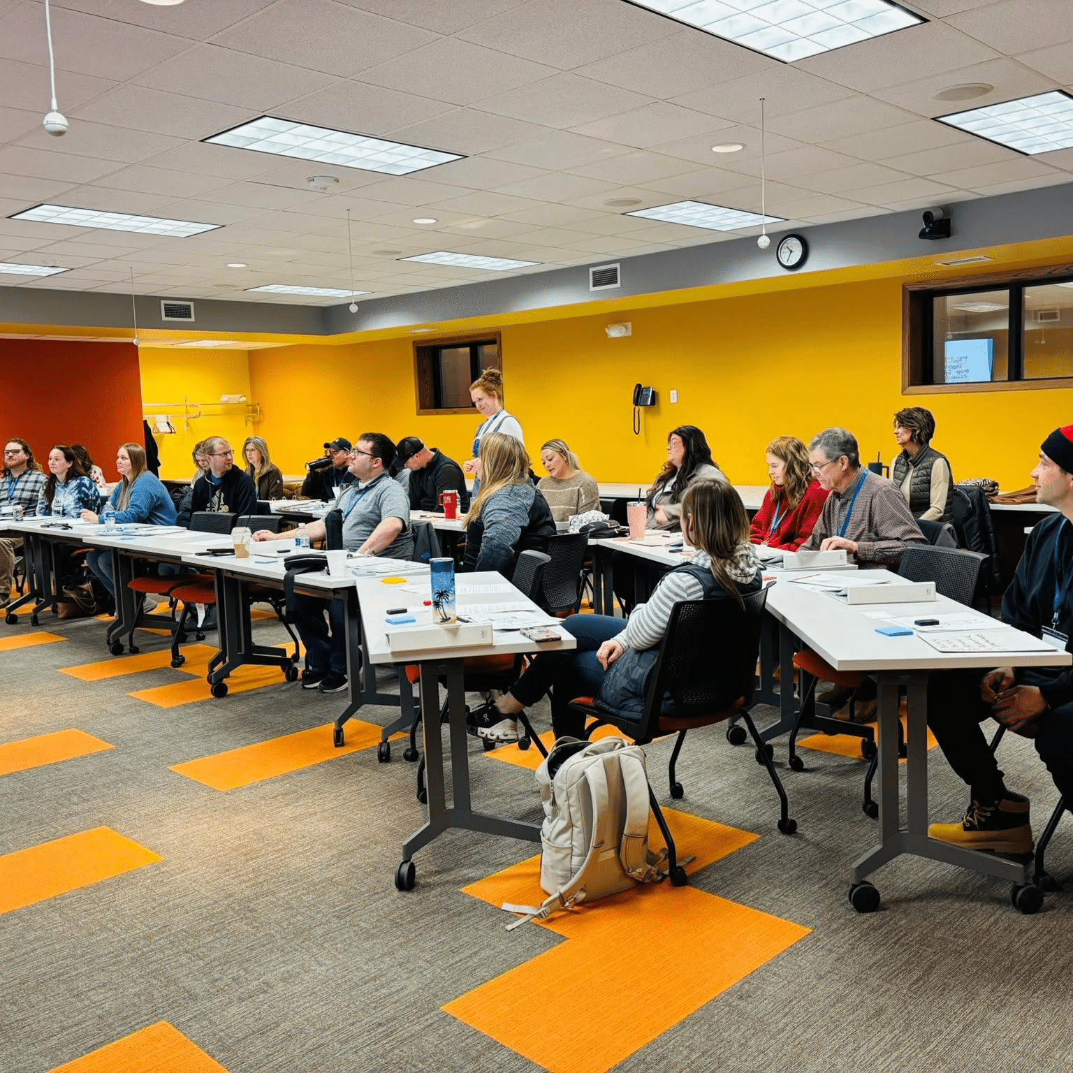 Team taking linc leadership training class in a bright yellow room