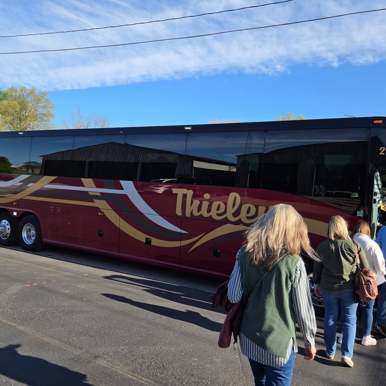 linc team climbing in red tour bus